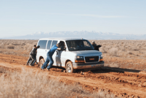 A group of men push a car that’s out of fuel.