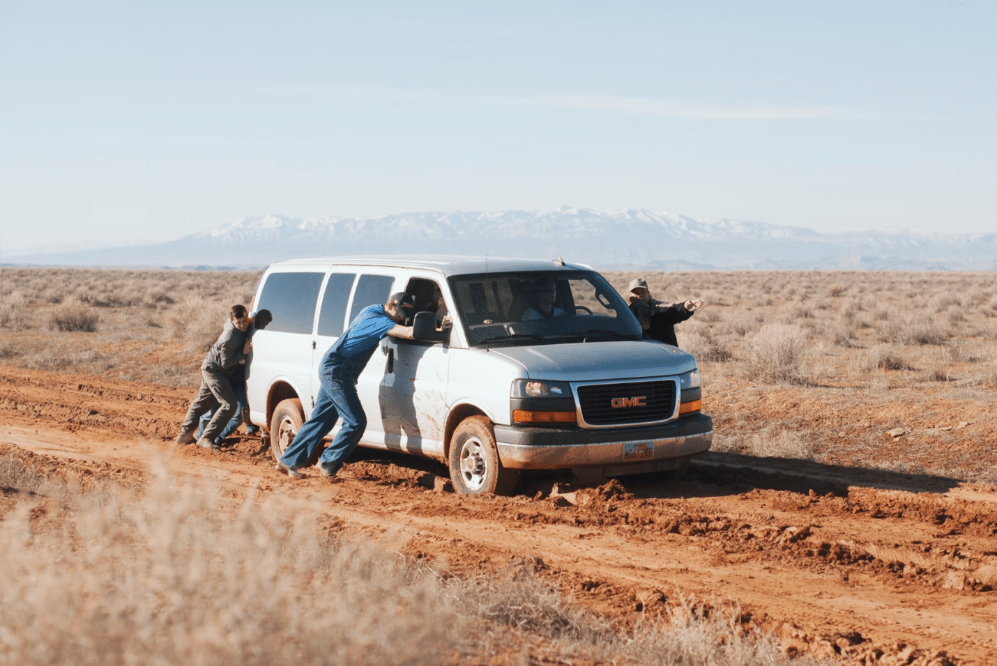 A group of men push a car that’s out of fuel.