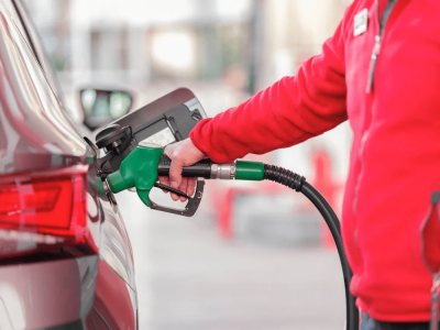 A person fills fuel in their car.